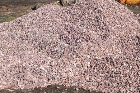 Crushed stone mound. Red crushed stones. Close up. Versatile building material for horticulture, landscape gardening or road construction. Material for railroad construction.