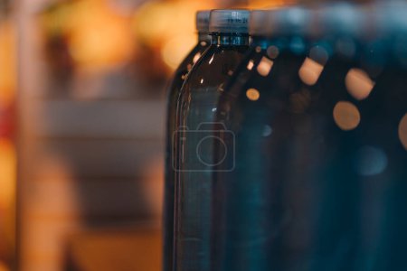 Foto de Primer plano de botellas de plástico de agua cruda. Línea de botellas de agua mineral azul, bebida natural transparente - Imagen libre de derechos