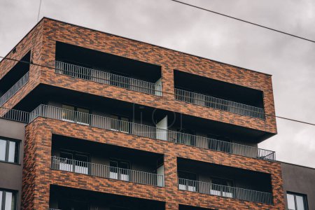Téléchargez les photos : Étages supérieurs de haut bâtiment résidentiel moderne, façade de construction contemporaine avec des cadres en brique sur le balcon - en image libre de droit