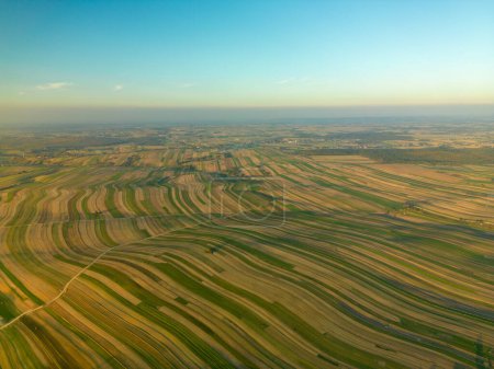 Téléchargez les photos : Vue de drone du paysage agricole sans fin avec la route à travers les champs sous le ciel bleu, village de Suloszowa dans le comté de Cracovie, Pologne - en image libre de droit