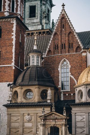 Statue du roi, lancette en mosaïque et fenêtres rondes et colonnes décoratives sur les murs du château royal de Wawel, Cracovie, Pologne