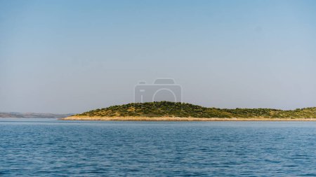 Narrow strip of shore in Dugi Otok island, clear sky and waves of Adriatic Sea, Croatia