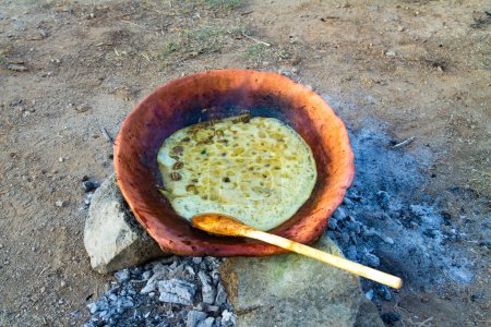Téléchargez les photos : Cuisine méditerranéenne anciens aliments délicats. Cuisson des escargots ragoût dans une casserole en terre cuite sur un feu de bois dans le centre rural de Crète. - en image libre de droit