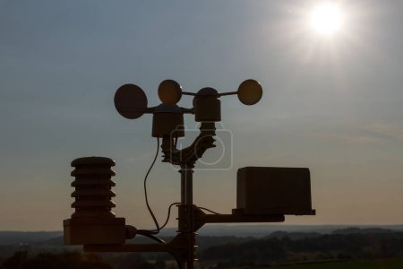 Foto de Una pequeña estación meteorológica en el fondo de la puesta de sol. Medición de velocidad del viento. - Imagen libre de derechos