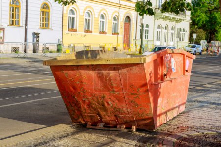 Grand conteneur vide en métal rouge pour la construction ou d'autres déchets encombrants dans le centre de la grande ville de Prague. Le concept de protection de l'environnement