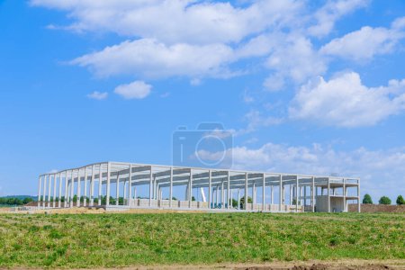 Outdoor view during under construction of metal frame for industrial warehouse using steel material