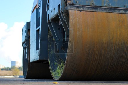 Foto de Cilindros pesados sucios del rodillo de carretera están esperando el trabajo - Imagen libre de derechos