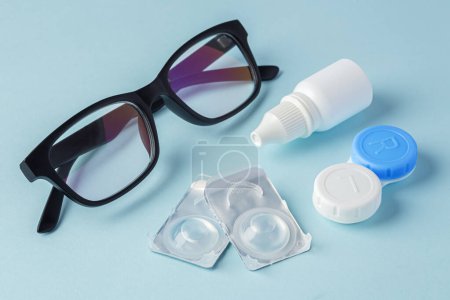 Photo for Eyeglasses and contact lenses with container on blue background - Royalty Free Image