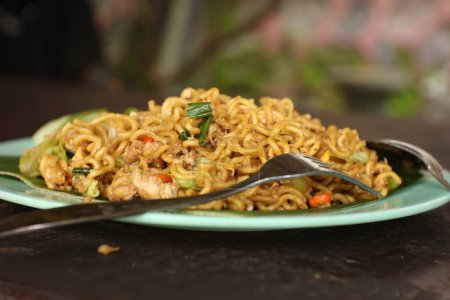 Photo for Delicious and delicious fried noodles on a plate covered with banana leaves. - Royalty Free Image