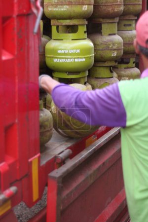 Foto de Los oficiales estaban descargando cilindros de gas LPG de 3 kg desde la parte superior del camión. - Imagen libre de derechos