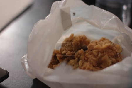 Téléchargez les photos : "Le poulet frit croustillant est enveloppé dans un sac en plastique blanc." - en image libre de droit