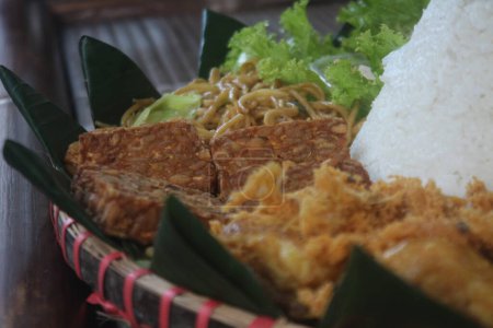 Foto de Nasi Tumpeng. Arroz amarillo en forma de cono. Un plato festivo de arroz indonesio con guarniciones se sirve en eventos religiosos.. - Imagen libre de derechos