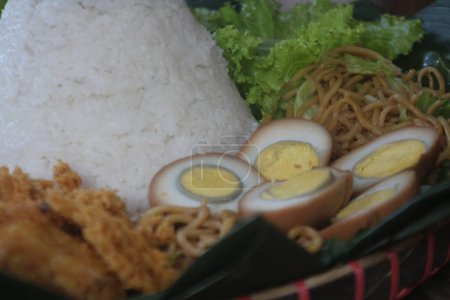 Nasi Tumpeng. Kegelförmiger gelber Reis. Ein festliches indonesisches Reisgericht mit Beilagen wird bei religiösen Anlässen serviert.