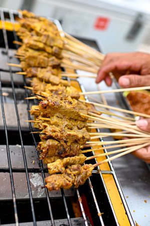 Sate Padang seen from the side is on a yellow grill