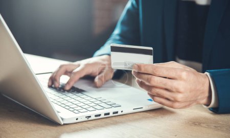 Téléchargez les photos : Homme main carte de crédit et ordinateur sur le bureau - en image libre de droit