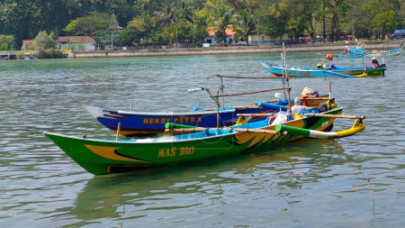 Foto de Kebumen, Java central Indonesia 23 de julio de 2023: Barcos de pesca tradicionales en el río con árboles verdes en el fondo - Imagen libre de derechos