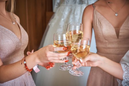 Foto de The bride and her friends drink wine and cheer each other on. Wedding theme. - Imagen libre de derechos
