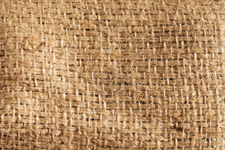 Foto de Detailed natural burlap background. The texture of the fabric of a brown coarse belt. - Imagen libre de derechos