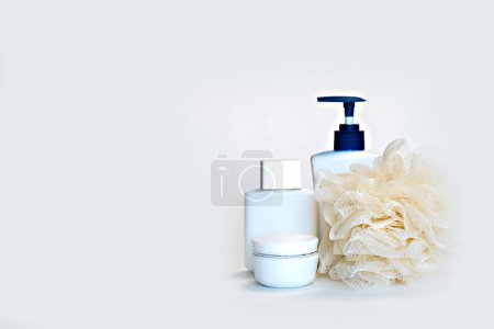 Foto de Botellas de color blanco con cremas y champús para procedimientos de spa sobre fondo blanco. Espacio para texto. - Imagen libre de derechos