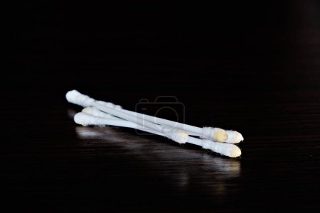 Foto de Hisopos de algodón usados para las orejas sobre un fondo oscuro. - Imagen libre de derechos