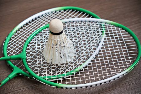 Photo for The shuttlecock rests on two badminton rackets. Professional sports equipment. - Royalty Free Image