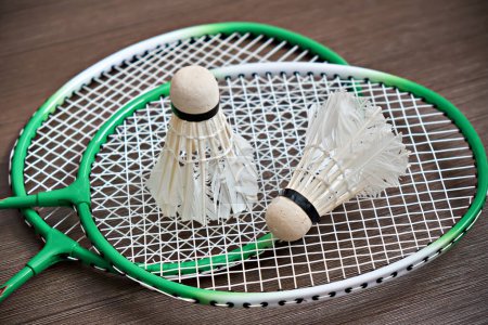 Photo for Two shuttlecocks lie on badminton rackets. Professional sports equipment. - Royalty Free Image