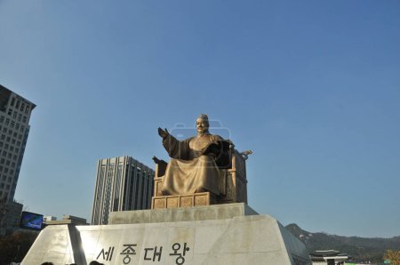Téléchargez les photos : SEOUL, CORÉE DU SUD - 23 OCTOBRE 2022 : Statue d'or du roi Sejong le Grand près du centre de la place Gwanghawmun, en face du palais Gyeongbokgung dans l'après-midi. Il y a son nom en alphabet coréen sur la statue. - en image libre de droit
