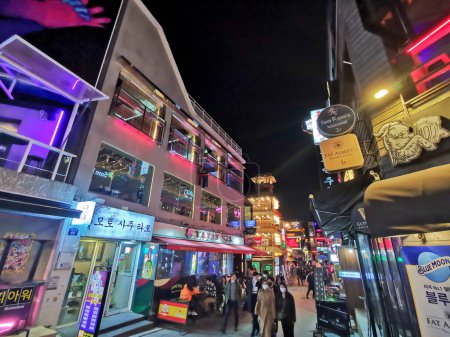 Téléchargez les photos : SEOUL, CORÉE DU SUD - 25 OCTOBRE 2022 : Itaewon célèbre allée de divertissement de nuit avec beaucoup de gens sur la rampe la nuit. Il y a beaucoup de gens qui portent des masques. - en image libre de droit