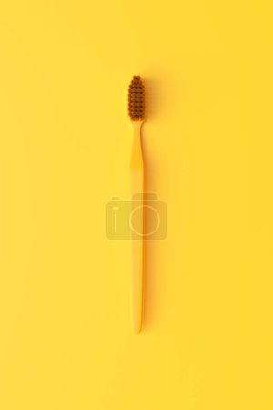 Foto de Cepillo de dientes de plástico de primer plano sobre el fondo amarillo con espacio para copiar. Ilustración de representación 3d - Imagen libre de derechos