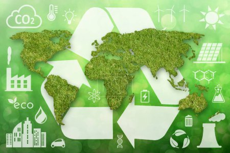 Eine grüne, grasstrukturierte Weltkarte, ein großes weißes Recycling-Symbol und andere weiße Ökologie-Symbole auf grünem, defokussiertem Hintergrund.