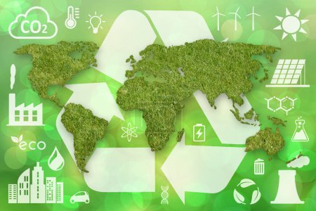 A green grass textured World map, a large white recycling symbol and other white ecology icons on green defocused background.
