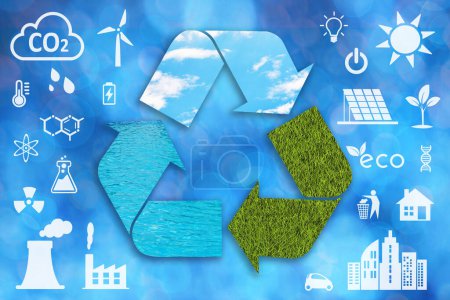 Un gran símbolo de reciclaje texturizado con agua, cielo azul y hierba verde y otros iconos de la ecología blanca sobre un fondo desenfocado.