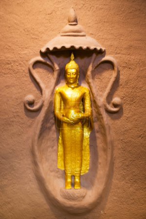 Téléchargez les photos : Sculpture sculpture bouddha et divinité ange sur le mur de terre pour le peuple thaï voyageurs voyage visite respect prière bénédiction mythe de Wat Rai Khing ou Raikhing temple à Sam Phran à Nakhon Pathom, Thaïlande - en image libre de droit