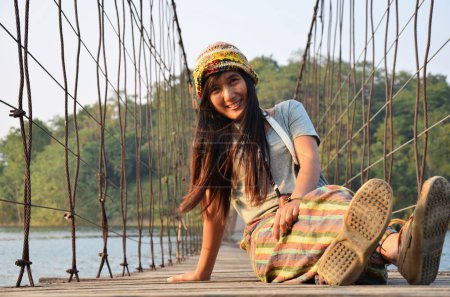 Foto de Travelers thai women photographer journey travel visit and posing portrait take photo on wooden suspension bridge crossing lake to island at Kaeng Krachan Dam National Park in Phetchaburi, Thailand - Imagen libre de derechos