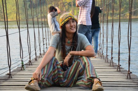 Foto de Travelers thai women photographer travel visit and posing portrait take photo on wooden suspension bridge  crossing lake to island at Kaeng Krachan Dam and National Park in Phetchaburi, Thailand - Imagen libre de derechos