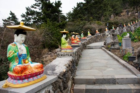 Photo for Colorful chinese god figure and deity angel buddha statue on stone stairs go to Sanbangsa mountain for korean people travelers travel visit respect praying in Sanbangsa Temple in Jeju do, South Korea - Royalty Free Image