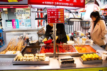 Téléchargez les photos : Local hawker stalle traditionnelle coréenne gourmet sur le marché de bazar de nourriture de rue pour les voyageurs les gens voyagent visite et manger des boissons à Nampo dong ou Gwangbok dong sur Février 18, 2023 à Busan, Corée du Sud - en image libre de droit