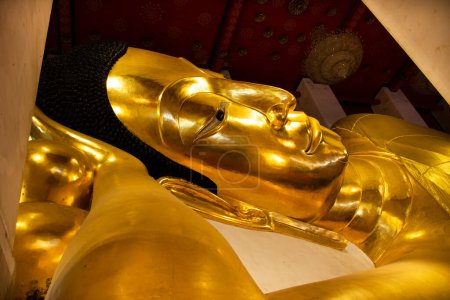 Téléchargez les photos : Statue inclinable de Bouddha de Wat Phra Non Chakkrasi Worawihan Temple royal pour les personnes thaïlandaises voyage visite et respect prière bénédiction souhait saint mystère culte à Sing Buri à Singburi, Thaïlande - en image libre de droit