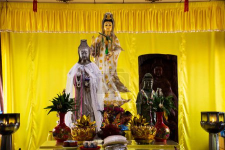 Téléchargez les photos : Ancienne divinité Quan Yin ou Kuan Yin statues de la déesse chinoise dans un ancien sanctuaire pour le peuple thaï respect et la prière mythe saint à Wat Phra Non Chakkrasi Worawihan Temple à Sing Buri à Singburi, Thaïlande - en image libre de droit