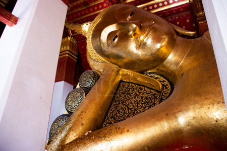 Foto de Antigua buda antigua actitud reclinable estatuas del templo de Wat Pa Mok Worawihan para los viajeros tailandeses de viaje de visita y respeto oración bendición deseo santo misterio adoración en Ang Thong, Tailandia - Imagen libre de derechos