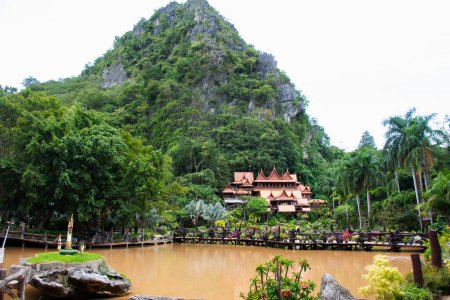 Photo for Antique wooden building thai style and gardening park garden with lake mountain for travelers people travel visit respat praying in Wat Tham Khao Wong Temple at Ban Rai city in Uthai Thani, Thailand - Royalty Free Image