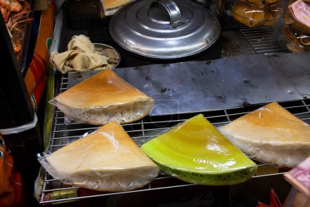 Téléchargez les photos : Dessert thaï traditionnel local khanom thang taek ou pauvre crêpe homme ou casse-croûte baril pour les voyageurs mangent boisson dans la rue marché bazar temple événement annuel festival à Nonthaburi, Thaïlande - en image libre de droit