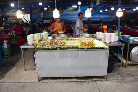 Foto de Cocinero tailandés cocina comida china hojas de arroz teochew rollo sopa de fideos con salsa de soja oscura y despojos de cerdo y carne estofada, huevo duro para la venta en el mercado el 1 de octubre de 2023 en Nonthaburi, Tailandia - Imagen libre de derechos