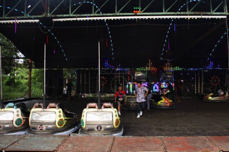 Foto de Coches de parachoques propulsados por electricidad o coche de juguete dodgems para niños y personas de la familia tailandesa jugando al parque de carnaval de atracciones en el festival anual del templo el 1 de octubre de 2023 en Nonthaburi, Tailandia - Imagen libre de derechos