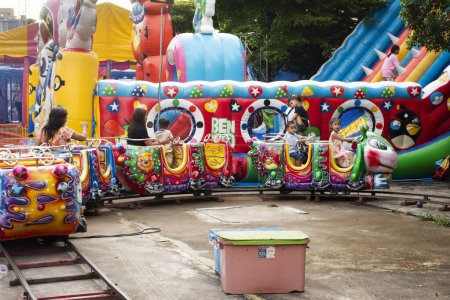 Foto de Tren de juguete para niños o vagón de ferrocarril para niños al aire libre para personas de la familia tailandesa y niños jugando al parque de carnaval de atracciones en el festival anual del templo el 1 de octubre de 2023 en Nonthaburi, Tailandia - Imagen libre de derechos