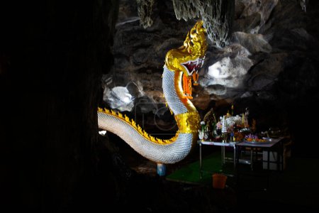 Téléchargez les photos : Ancienne naga ou antique statue de naka pour les thaïs voyageurs voyage visite et respect prière bénédiction souhait mythe ou saint mystère dans la caverne à Wat Tham Nam ou Temple de la grotte de l'eau à Ratchaburi, Thaïlande - en image libre de droit