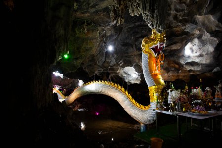 Téléchargez les photos : Ancienne naga ou antique statue de naka pour les thaïs voyageurs voyage visite et respect prière bénédiction souhait mythe ou saint mystère dans la caverne à Wat Tham Nam ou Temple de la grotte de l'eau à Ratchaburi, Thaïlande - en image libre de droit