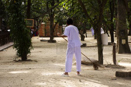 Foto de Retiro de meditación practicante tailandés respecto a la oración santa observar los preceptos religiosos y limpiar el piso de barrido en el área de práctica de Dhamma en el templo de Wat Maheyong el 3 de diciembre de 2023 en Ayutthaya, Tailandia - Imagen libre de derechos