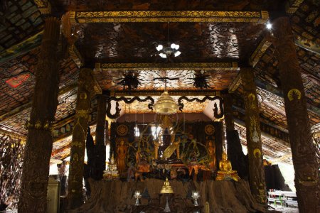 Téléchargez les photos : Sculpture d'art sculptant un dieu bouddha antique en bois et un ange divin antique en bois pour le peuple thaï visite respect priant la bénédiction du temple Wat Tham Khao Prathun à Ban Rai à Uthai Thani, Thaïlande - en image libre de droit