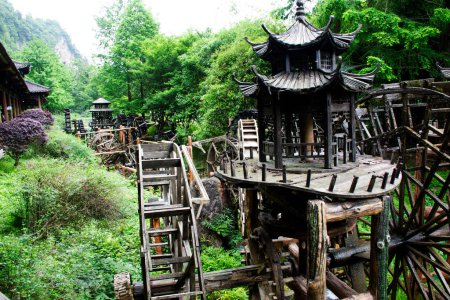 Alte Gebäude hölzerne Turbine Ballenpresse oder antike Architektur Holz Wasserräder chinesischen Stil in Kanal zur Wasseraufbereitung auf Teich in Huanglong Dong Scenic Area in der Stadt Zhangjiajie in Hunan China